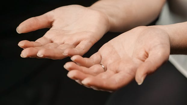 A close-up view of two open adult hands with a visible ring.