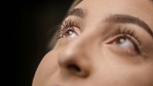 Free A striking close-up photo of a woman's eyes gazing upward, emphasizing eyelashes and vision. Stock Photo