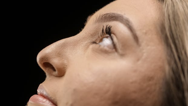Detailed view of a person's face looking upwards, focusing on eyes and eyelashes.