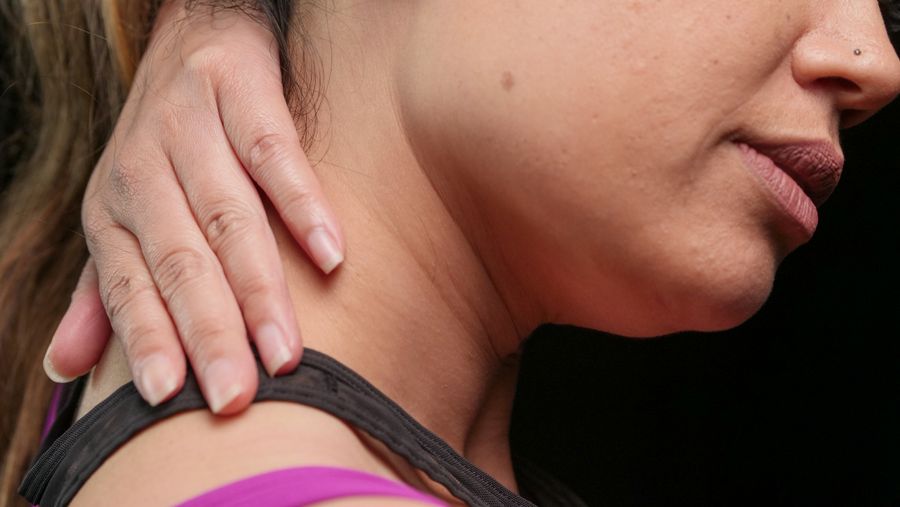 Person holding a tense shoulder and neck area