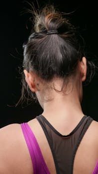 Rear view of a woman in activewear, highlighting her ponytail and tattoo.