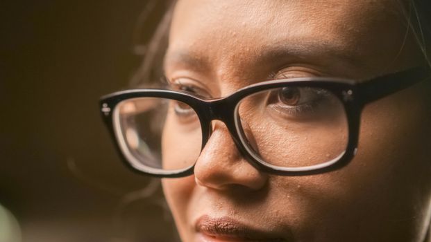 Detailed close-up of a person wearing eyeglasses, showcasing focus and contemplation.