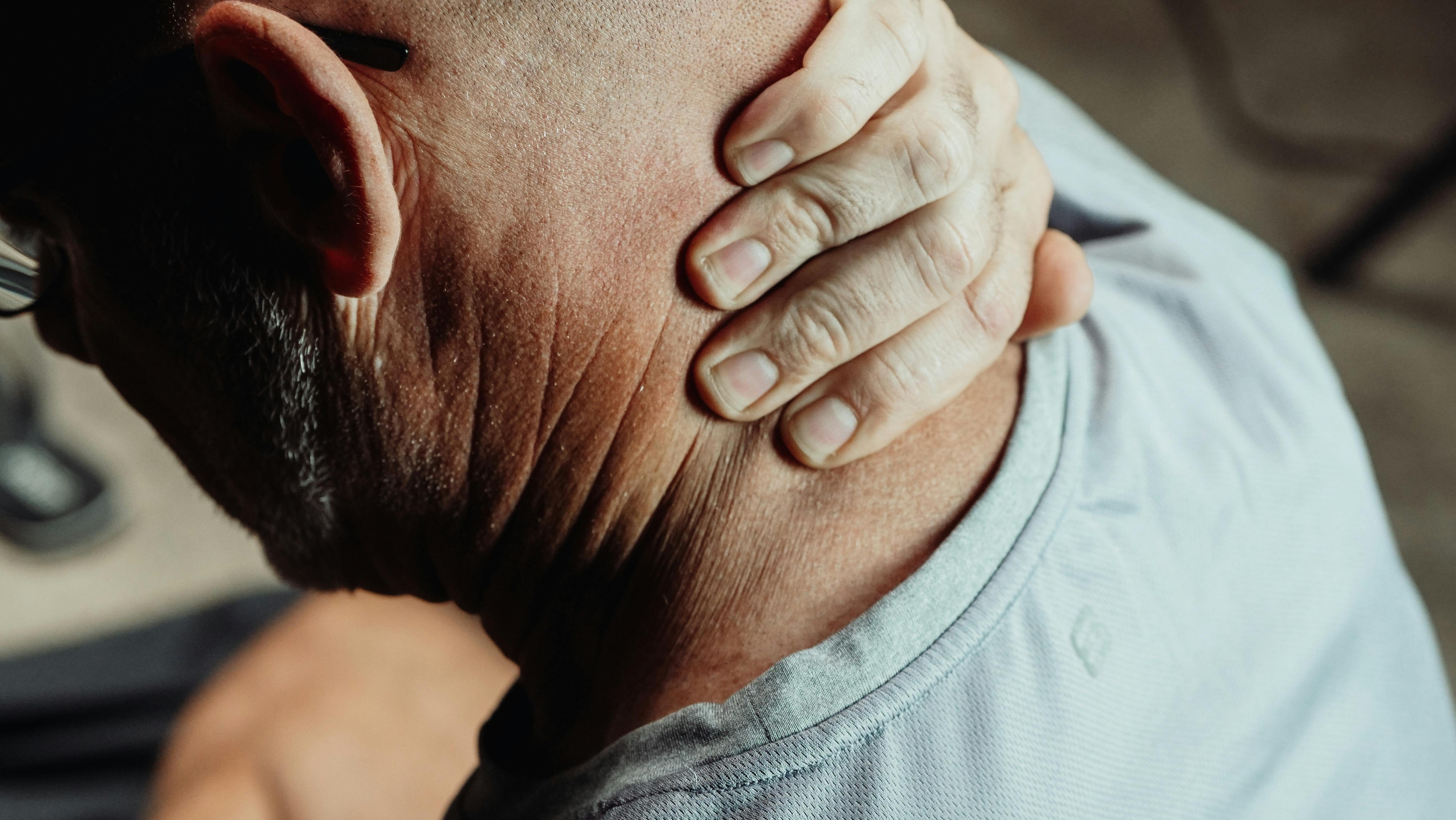 close up photo of a man having a neck pain