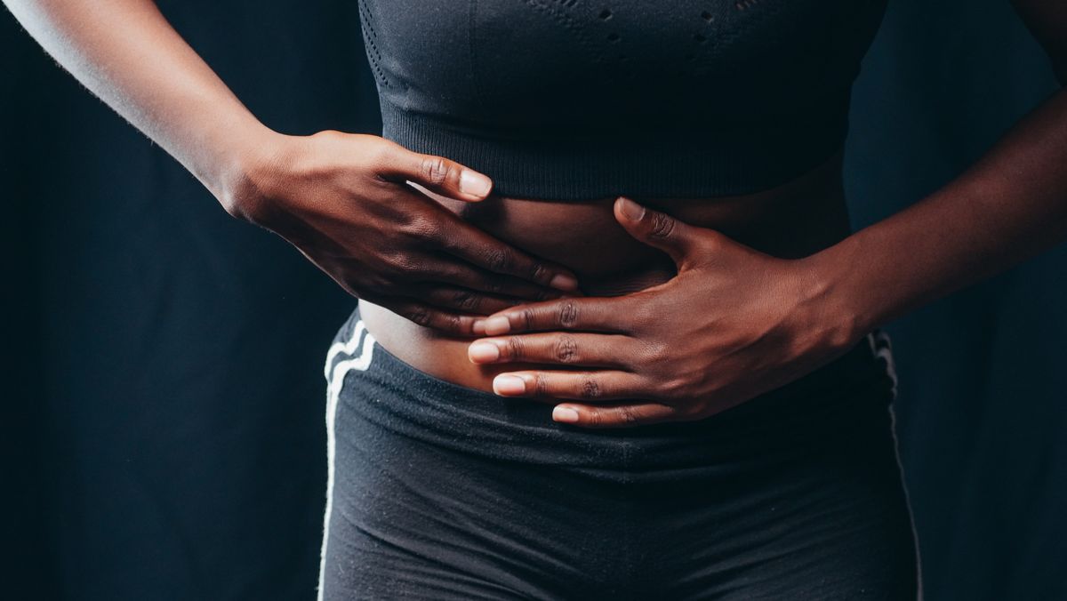 woman holding her stomach needing castor oil pack for constipation