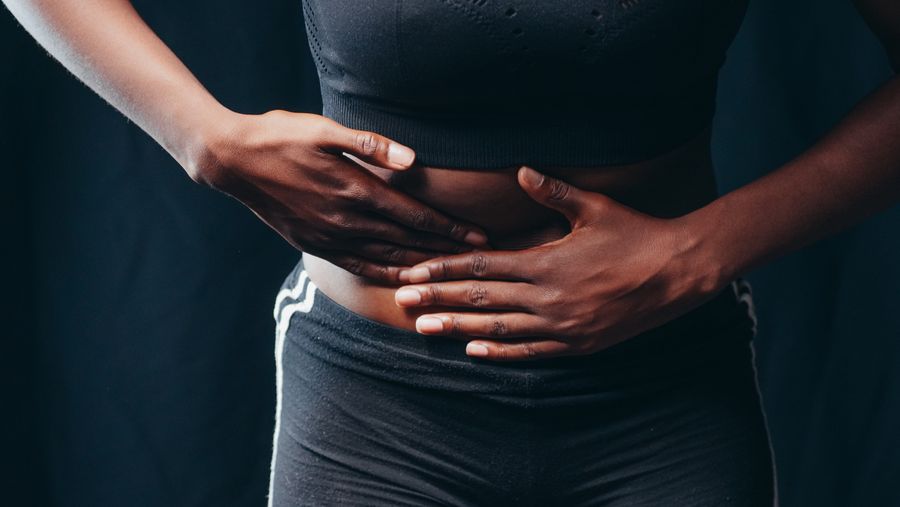 A person pressing both hands against the upper abdomen in discomfort