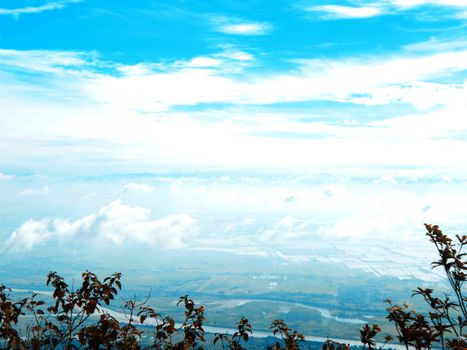 A scenic aerial view showcasing a vibrant blue sky over a lush landscape with distant clouds.