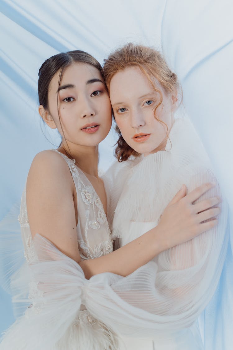 Women In Wedding Gowns Holding Each Other Close