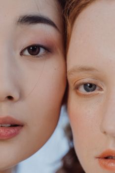 Artistic close-up of two women highlighting contrasting eye colors and features.