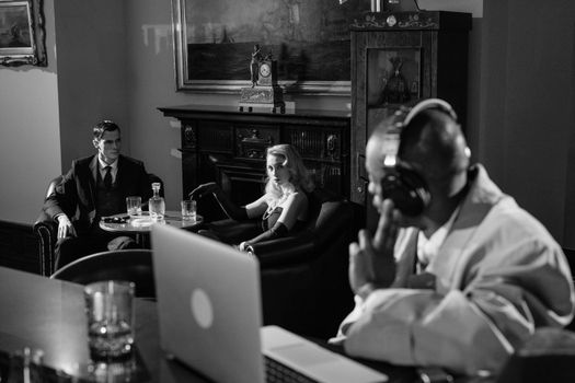 Photo of Couple Suspiciously Looking at Man with Headphones