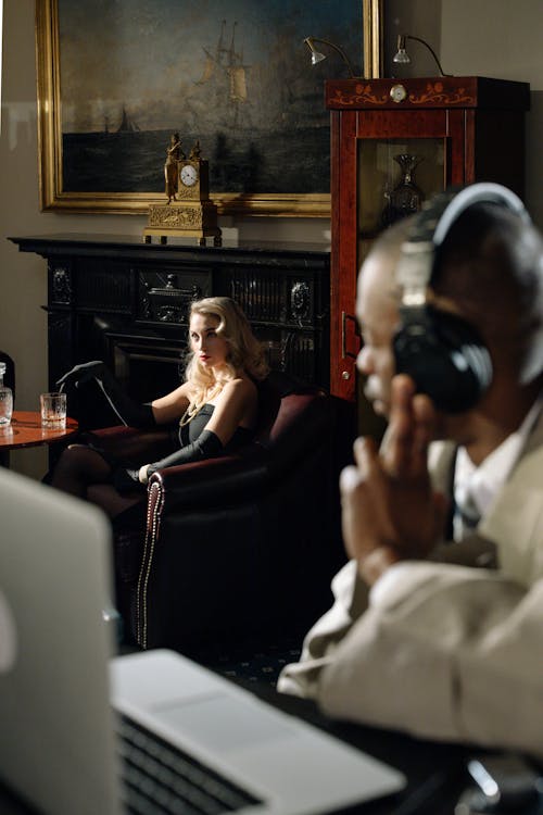 Photo of Woman in Black Dress Sitting on a Sofa