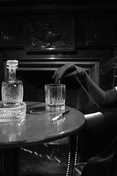 A mysterious woman in black gloves reaches for a drink in a vintage noir setting.