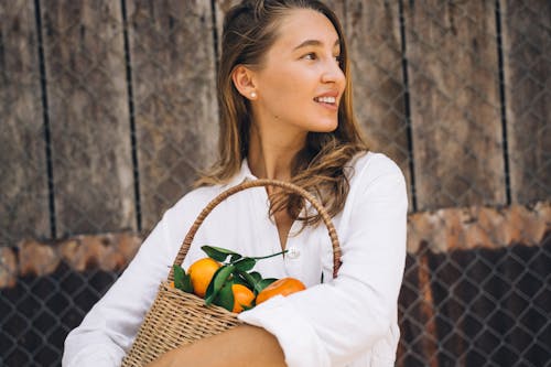 Free A Woman Carrying Basket with Orange Fruit Stock Photo