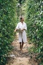 A Woman Carrying a Round Winnower with Freshly Harvested Fruits