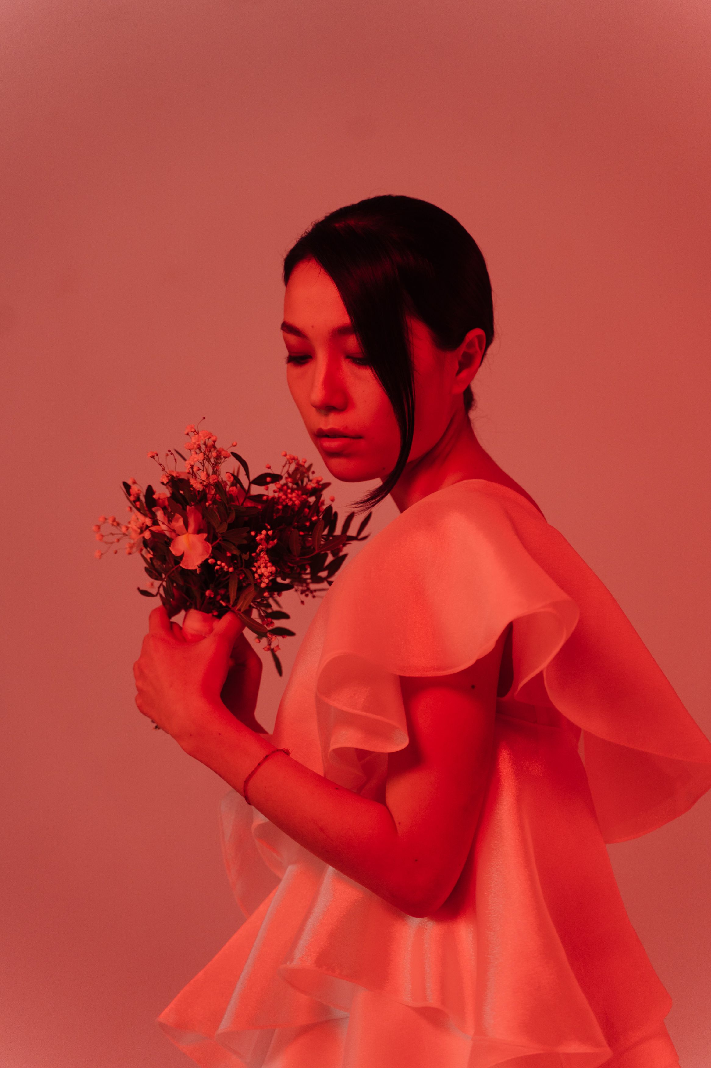 Woman in white dress holding pink flowers · Free Stock Photo