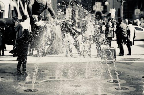 Black and White Photo of Fountain and People
