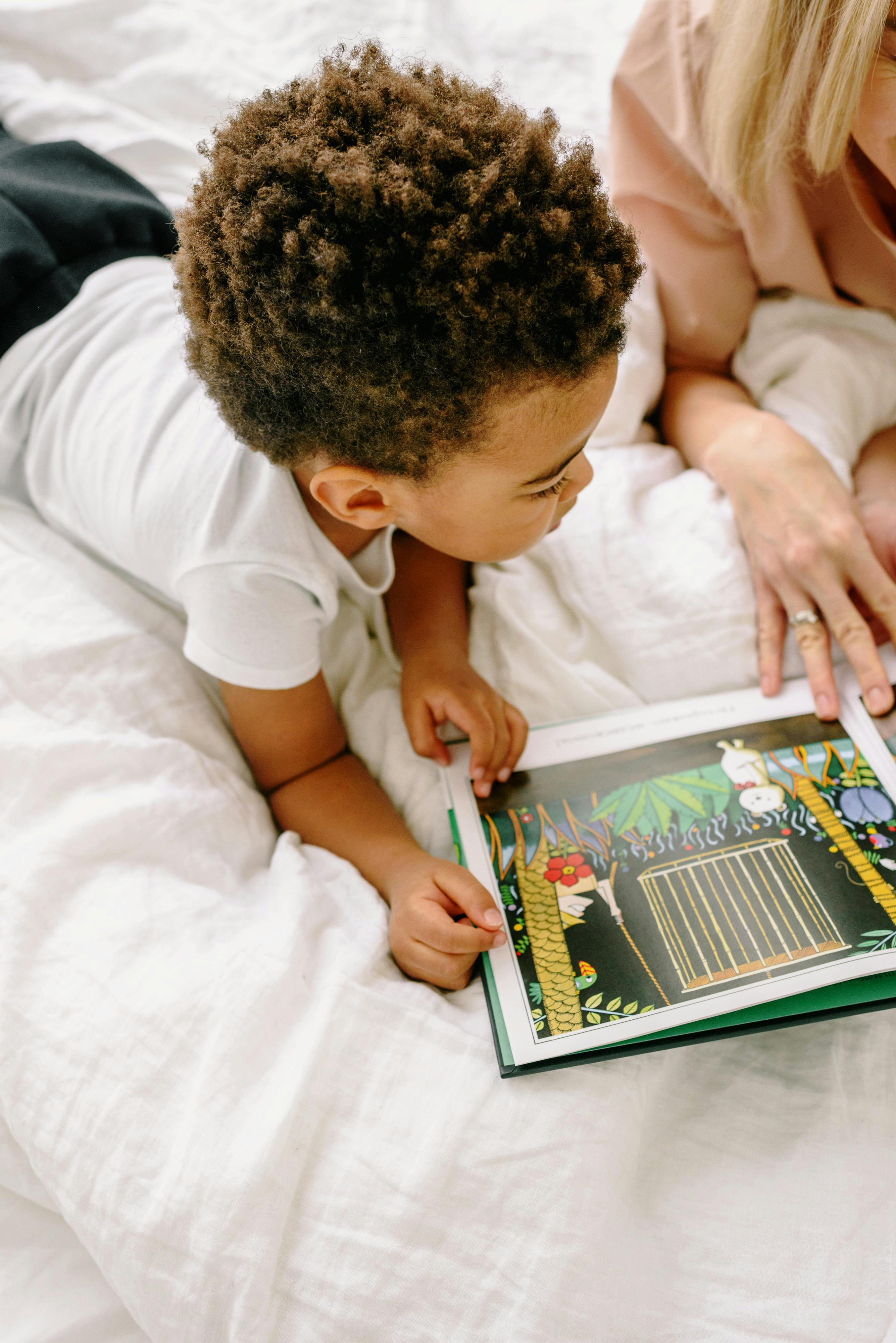 a boy reading a book with his mother