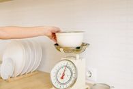 A Person Weighing the Ingredients on the Bowl