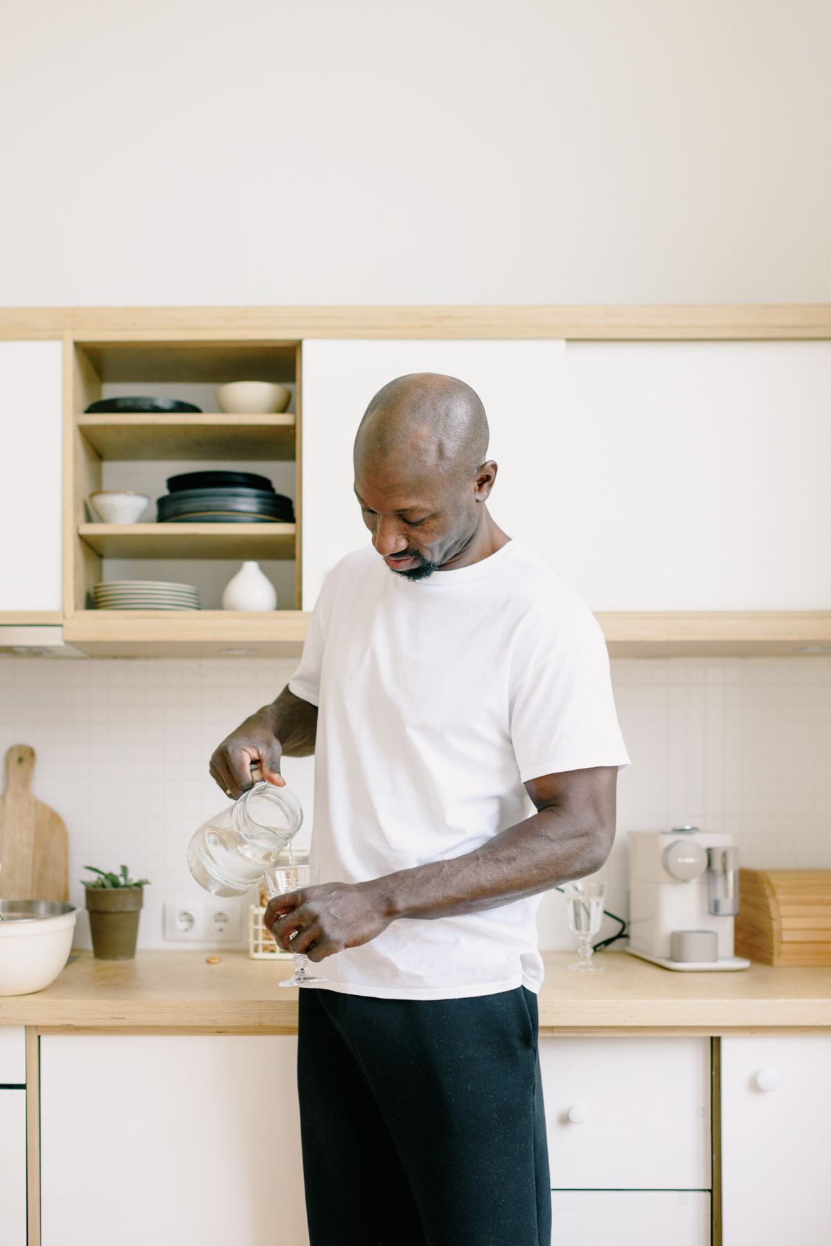 A person pouring drinking water into a glass at home