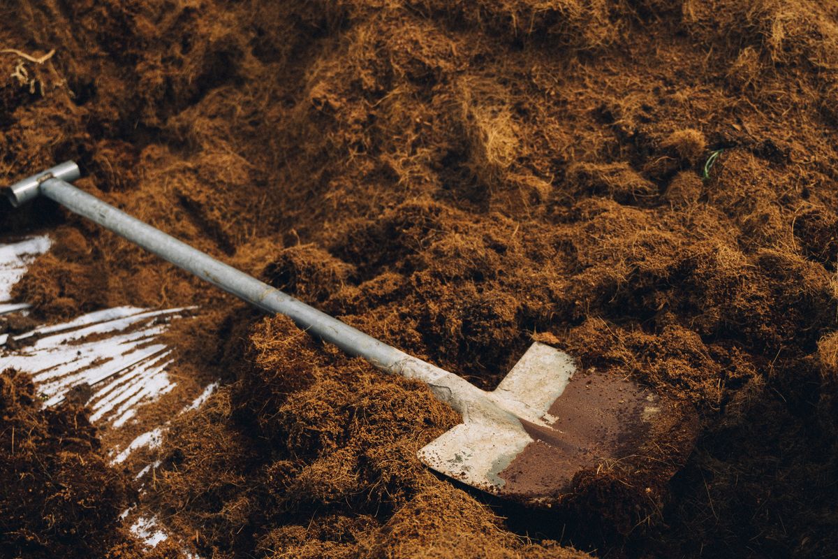 Shovel resting on a pile of rich soil