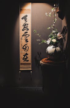 Serene indoor scene featuring a calligraphy scroll and floral arrangement, perfect for tranquil settings.