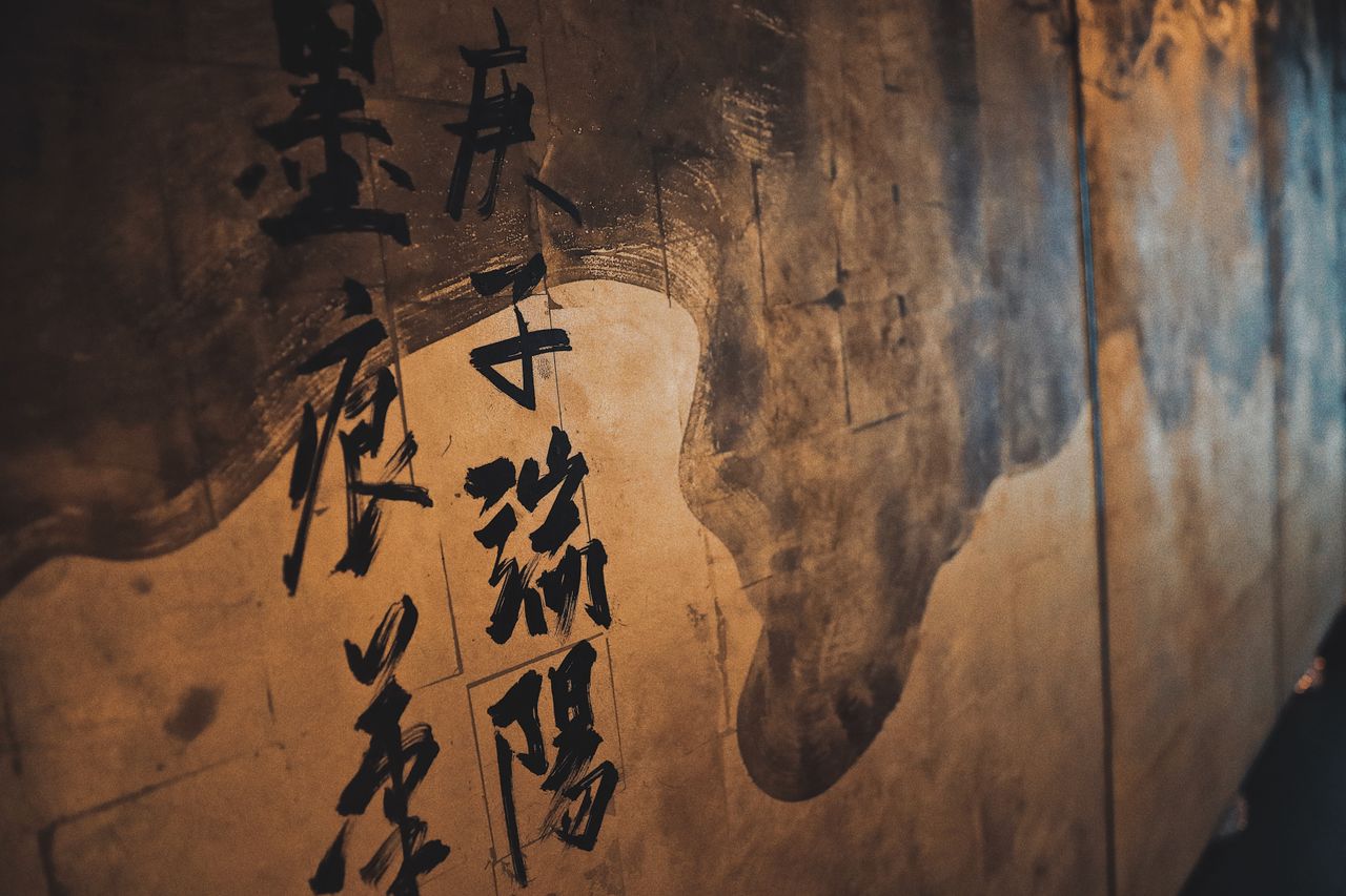 artistic close up of japanese calligraphy on a textured wall highlight