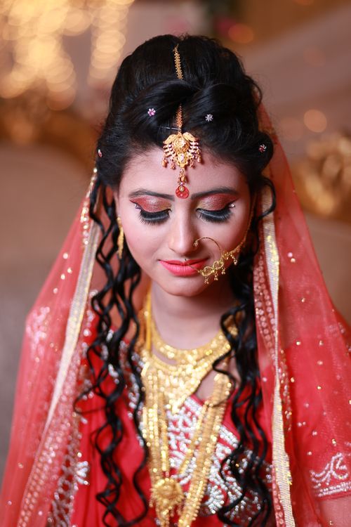 Free Stunning portrait of a bride in traditional attire with intricate jewelry and vibrant veil. Stock Photo
