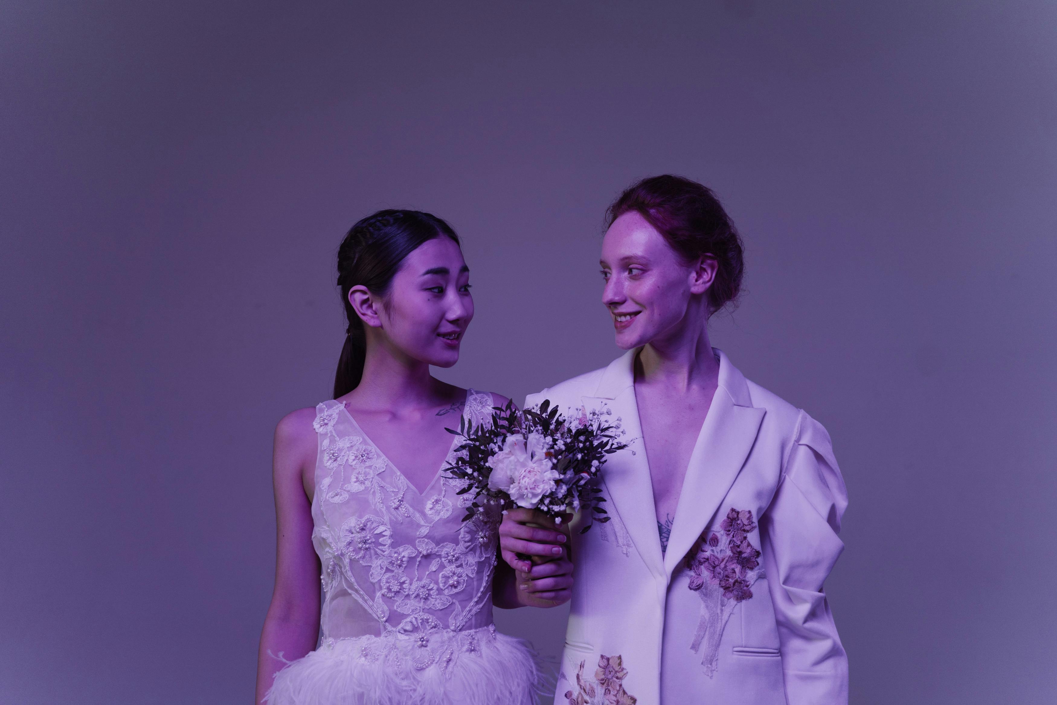 a couple holding a bouquet together looking at each other