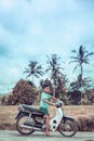 Boy Riding on White and Red Underbone Motorcycle