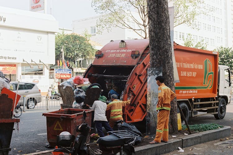 People Near The Garbage Truck On Street