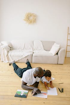 A father and son enjoy quality time drawing together on the living room floor, fostering creativity and bonding.