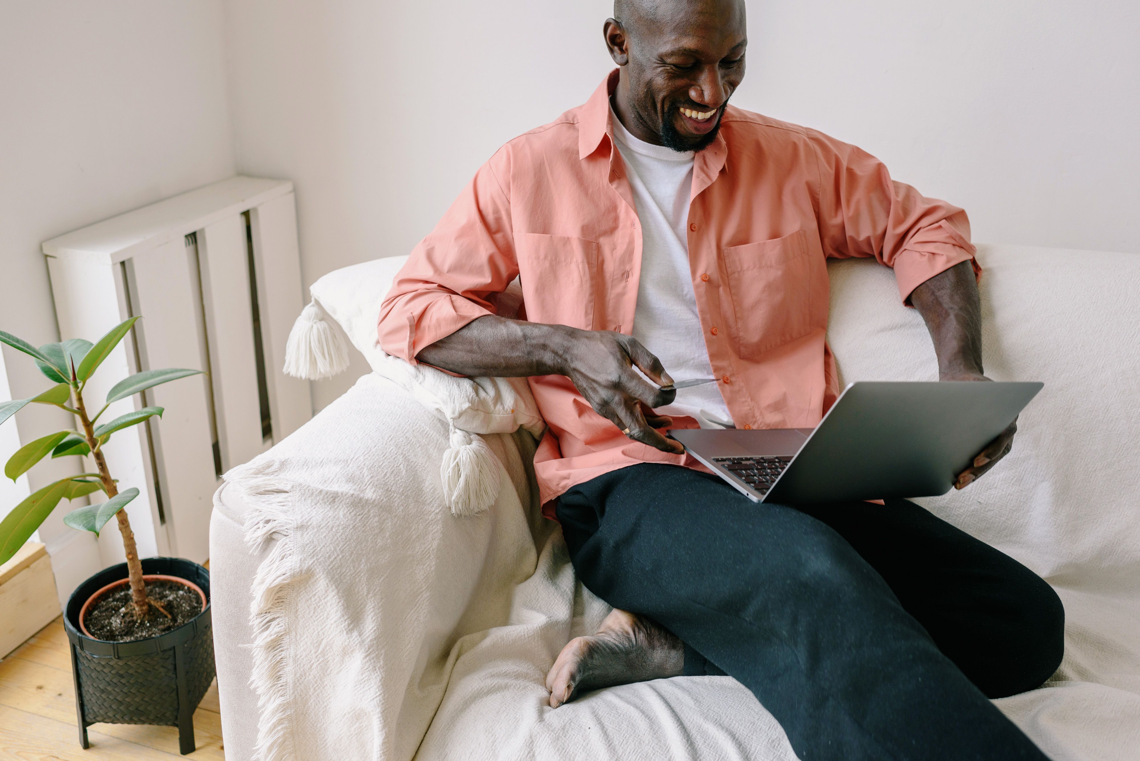 person comparing furniture prices on laptop smiling