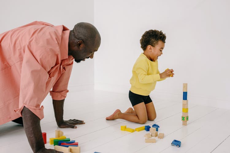 A Man Crawling While Playing With His Son