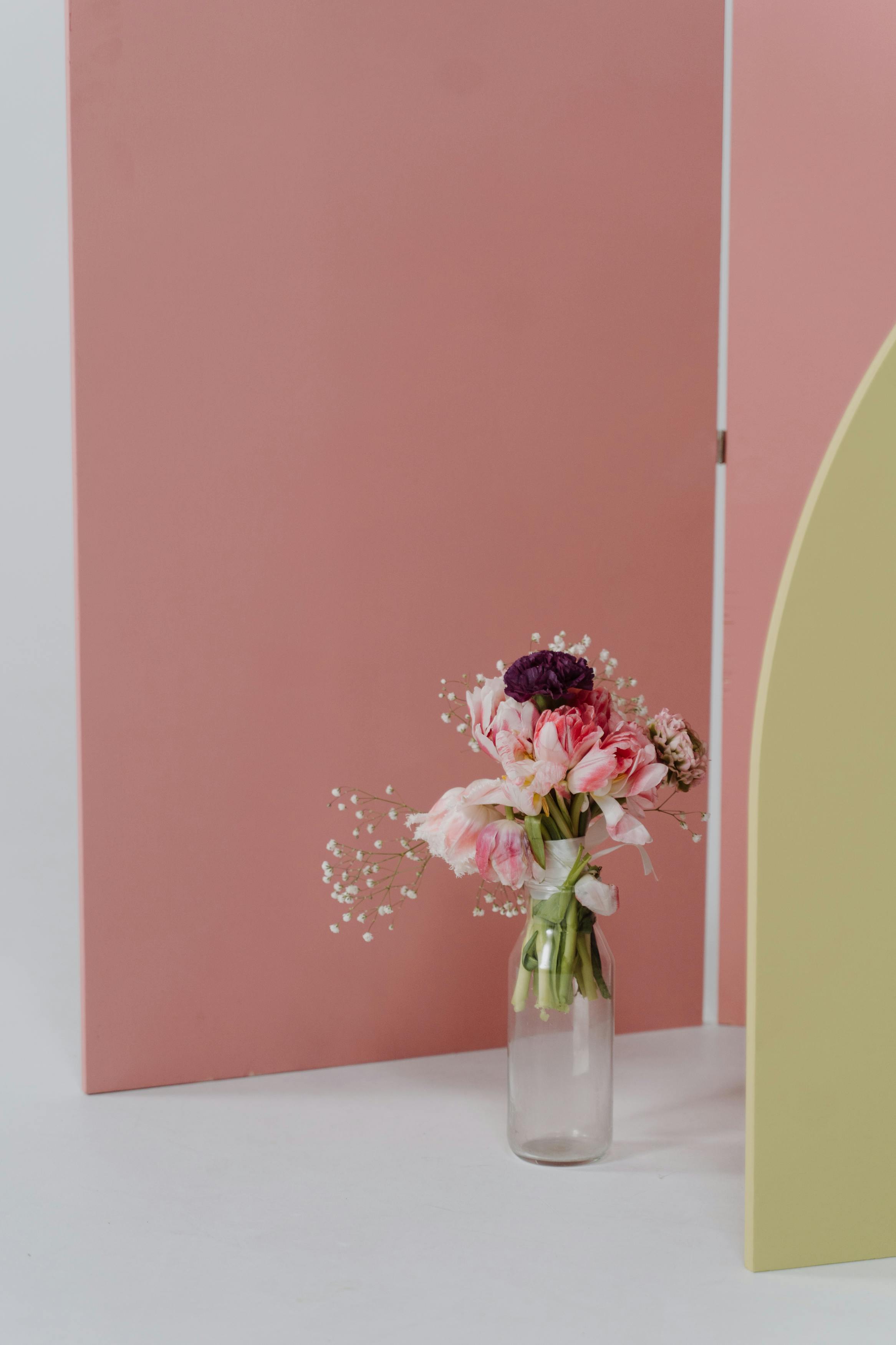 Colorful floral bouquet in a minimalist vase against pastel backdrop with copy space.