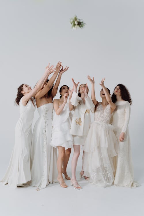 Free Women in White Dresses Raising Hands Stock Photo