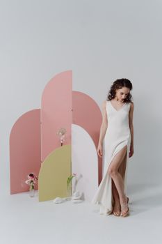 Sophisticated bride in white dress with pink and green decor, exuding modern elegance.