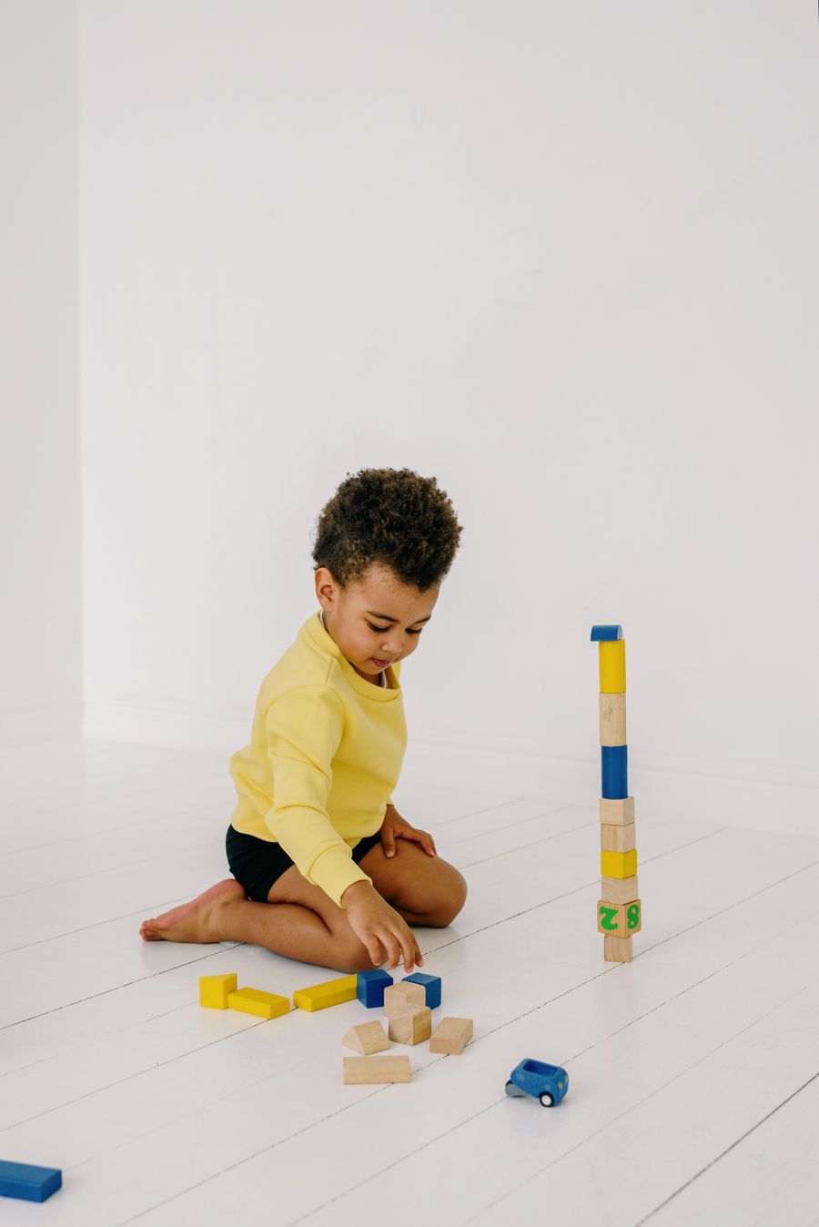 Child practicing speech sounds while playing with wooden blocks