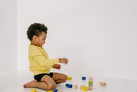Little boy playing with wooden block toys on the floor