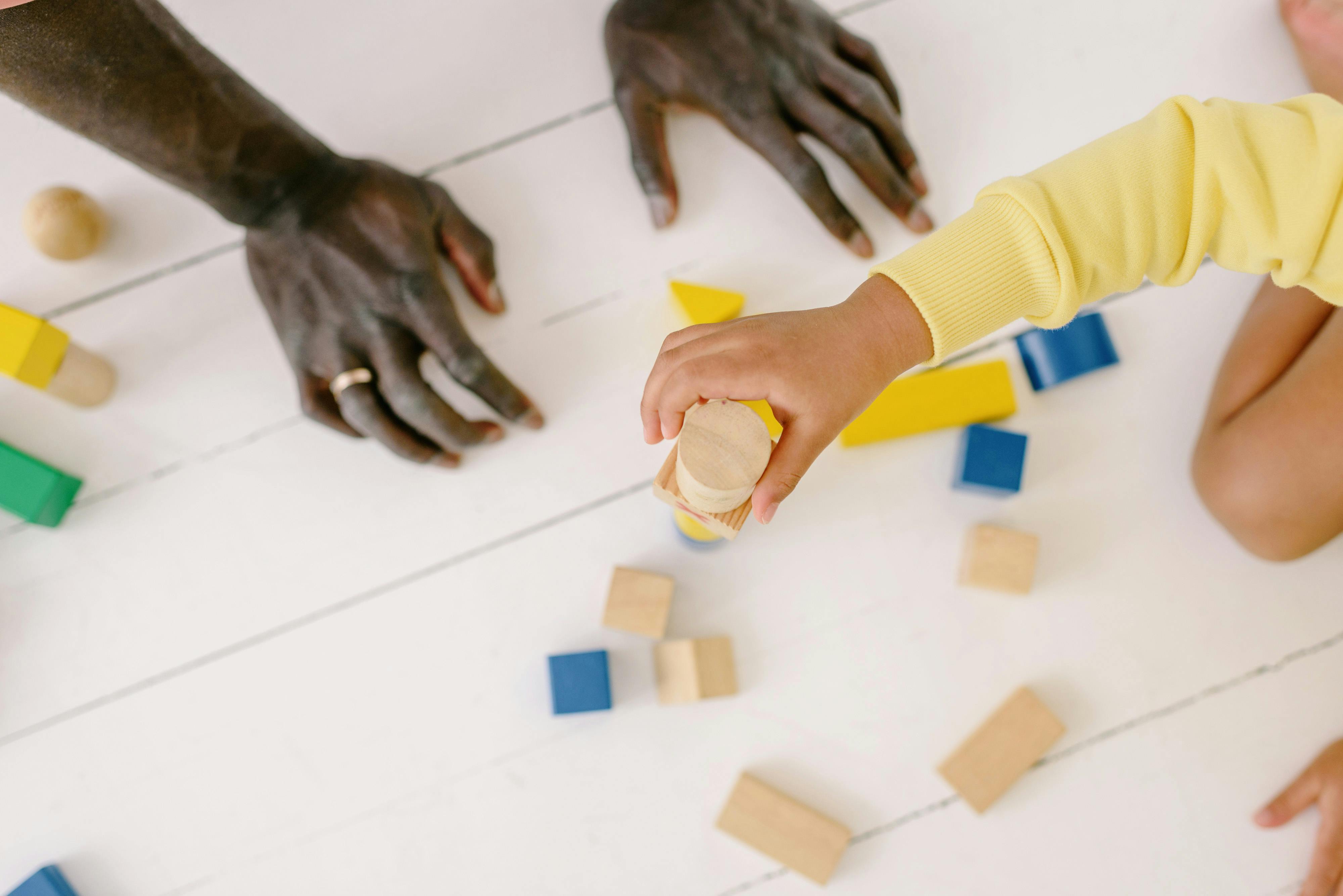 Child Holding a Wooden Toy · Free Stock Photo