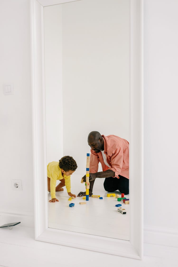 Father And Son Playing Toy Blocks On The Floor