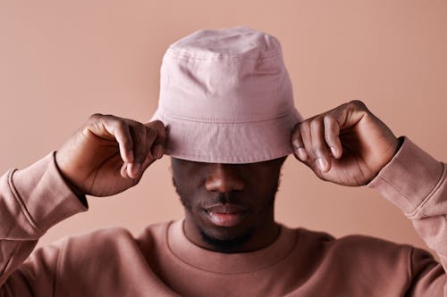 A Man Wearing Sweatshirt Covering His Face with the Hat