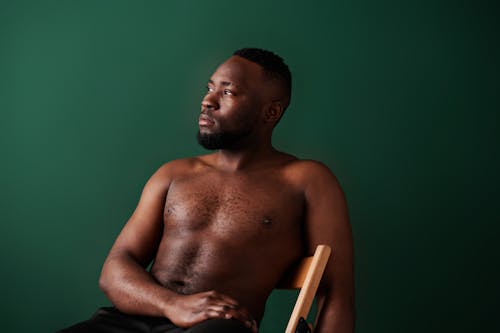 Shirtless Man Sitting on a Chair