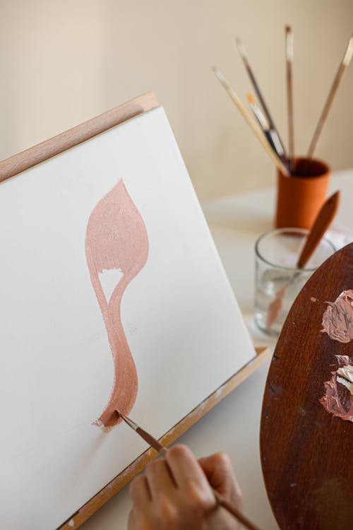 Close-up of a Person Painting on Canvas Holding a Wooden Painting Palette 