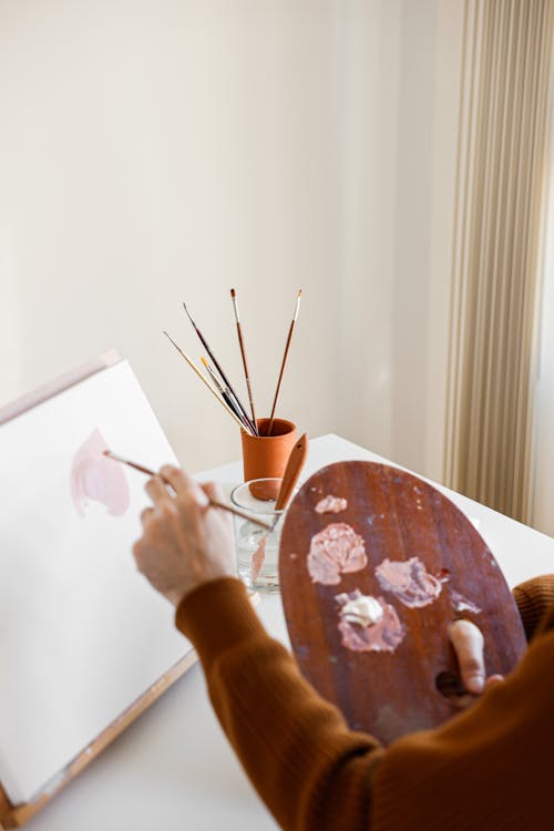 Person Holding Brown Wooden Round Table