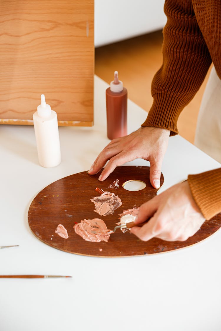 A Person Mixing Paint On The Palette