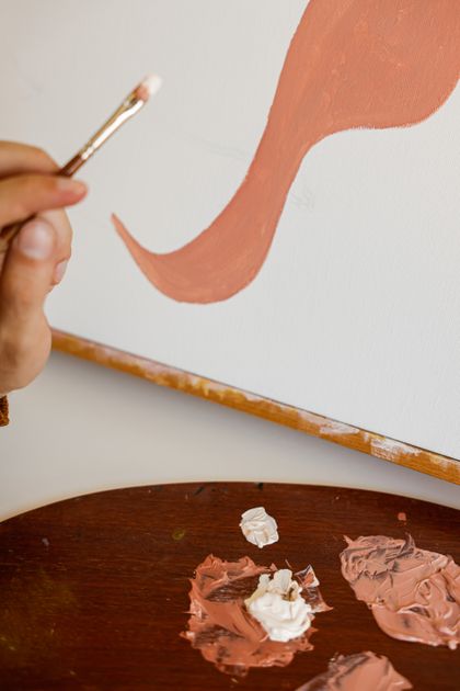 Artist's hand painting on a canvas with a brush — photo by Cup of Couple on Pexels