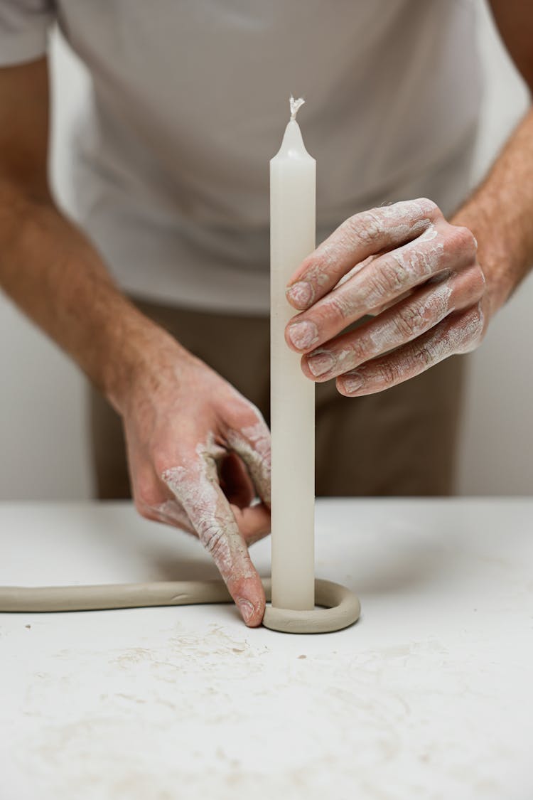 Person Shaping A Clay With Candle