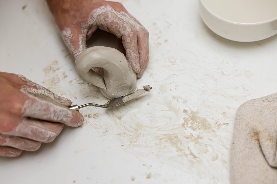 A Ceramist sing Palette Knife in Shaping Clay