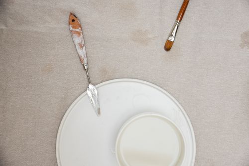 Free Top view of art tools, including a palette knife and brushes, on a beige background. Stock Photo
