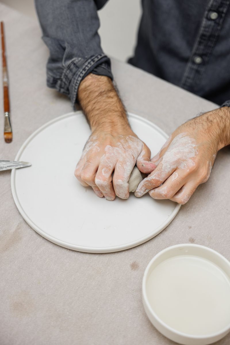 Hands shaping clay on the wheel