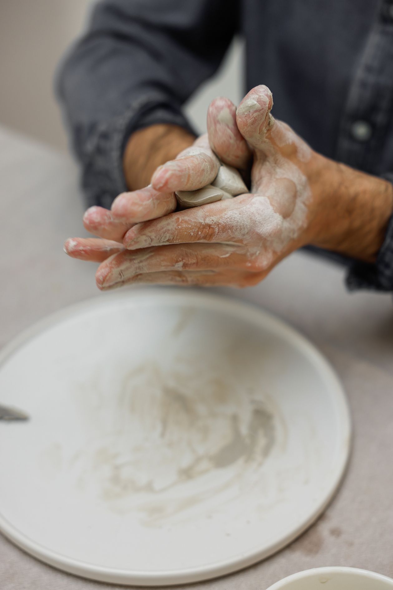Close view of hands shaping clay on a pottery wheel
